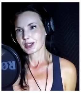 A woman in front of a professional microphone, speaking.